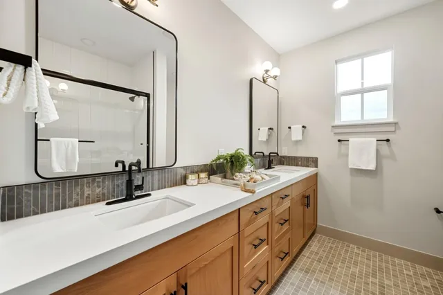 a bathroom with a double vanity sink and mirror