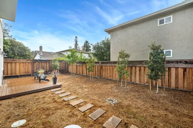 a view of a backyard with a patio and wooden fence