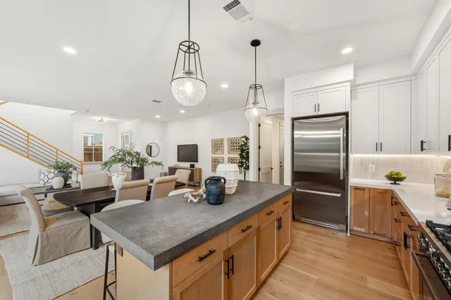 a kitchen with stainless steel appliances granite countertop a sink refrigerator and cabinets