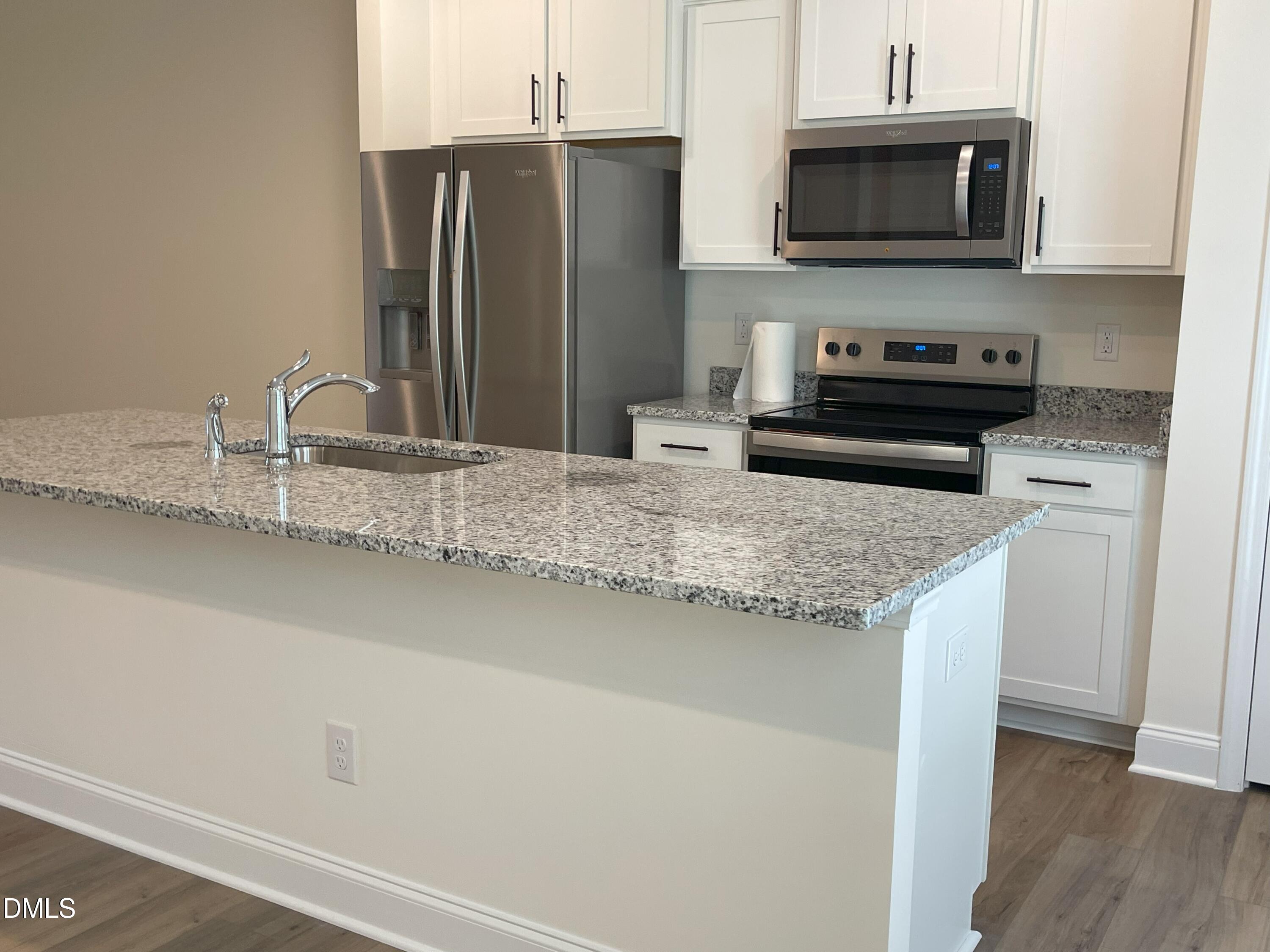 6404 Lady Eliza Lane Raleigh, NC 27610 - Photo 13 of 37 a kitchen with stainless steel appliances granite countertop a sink a microwave refrigerator and a stove with wooden floor
