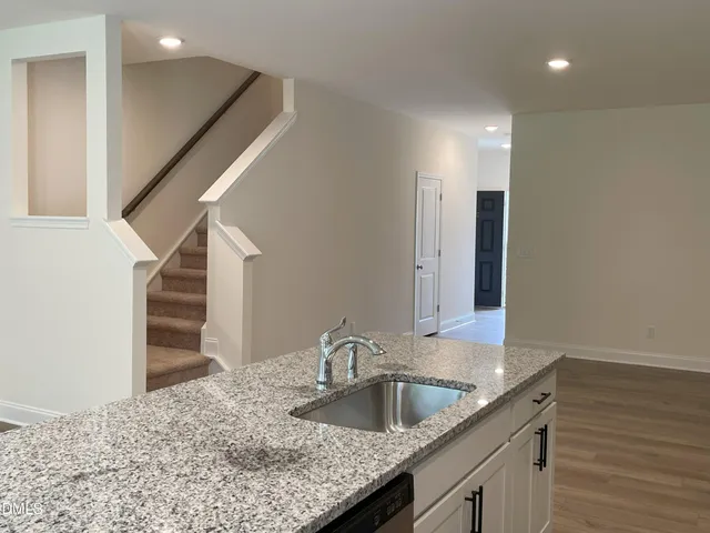 a utility room with granite countertop cabinets and sink