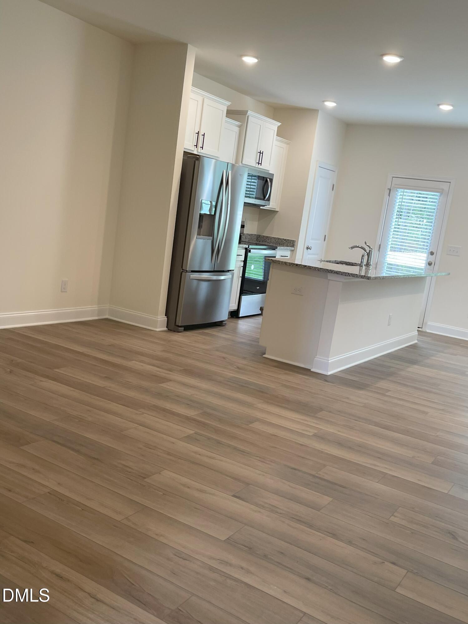 6404 Lady Eliza Lane Raleigh, NC 27610 - Photo 6 of 37 a view of kitchen with stainless steel appliances wooden floor and window