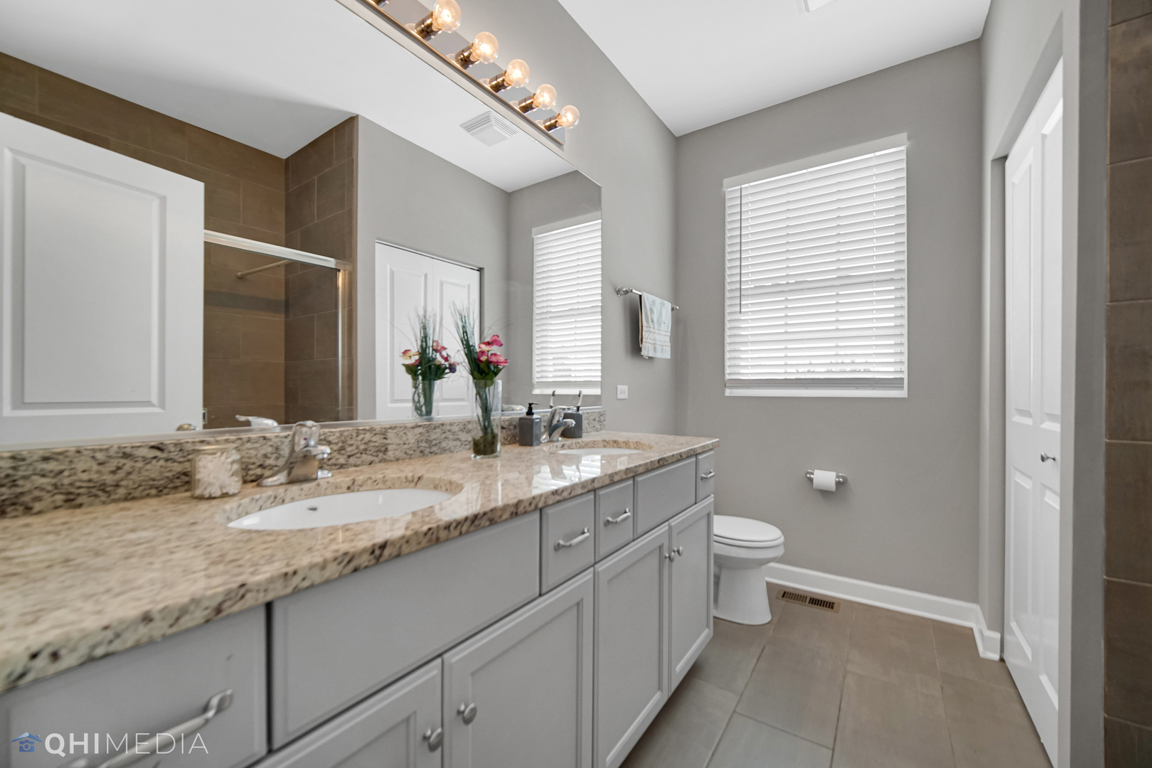 16432 Mueller Circle Plainfield, IL 60586 - Photo 15 of 22 a bathroom with a granite countertop sink a toilet and a large mirror