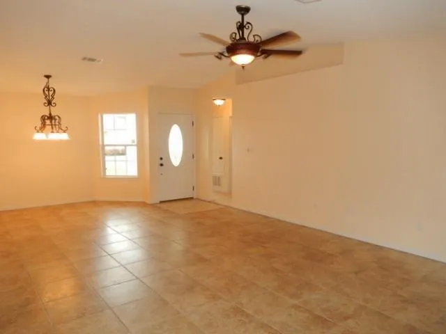 en empty room with windows and ceiling fan