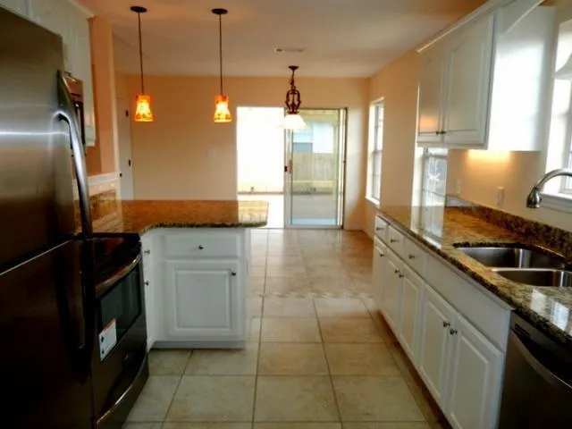 a kitchen with stainless steel appliances granite countertop a sink a stove and a refrigerator