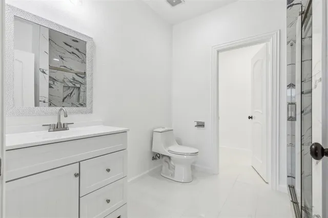 a bathroom with a toilet a sink a mirror and vanity