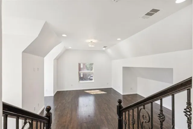 a view of a hallway with wooden floor and stairs