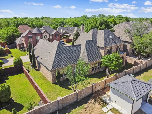 an aerial view of a house with swimming pool and a yard