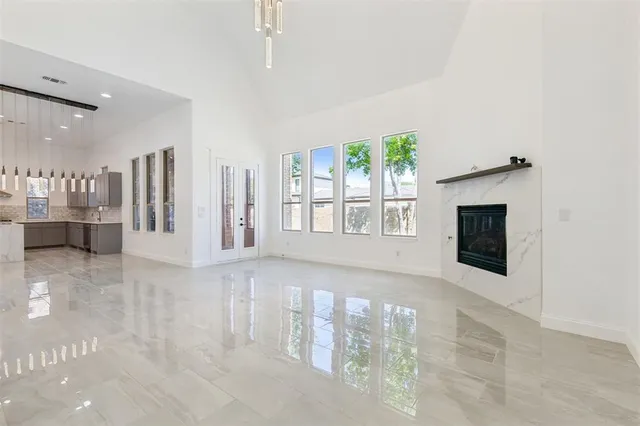 a view of an empty room with a fireplace and a window