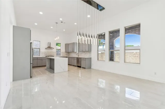 a view of kitchen with stainless steel appliances refrigerator stove microwave and cabinets
