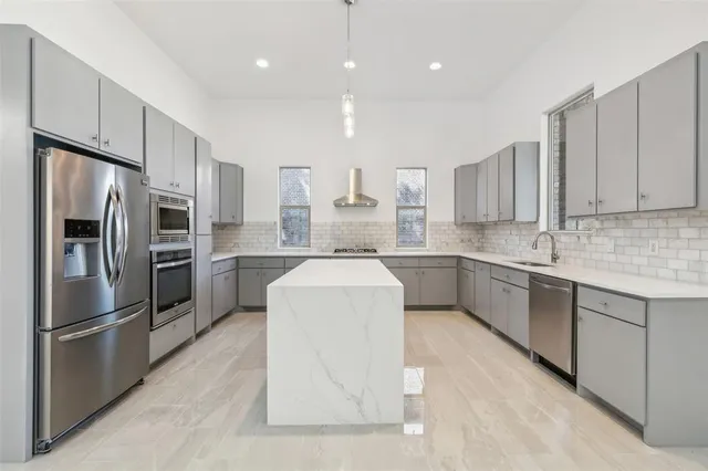 a kitchen with stainless steel appliances a refrigerator sink and cabinets
