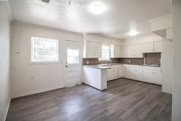 a view of a kitchen with wooden floor and electronic appliances