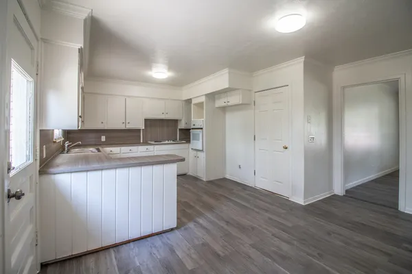 a kitchen with kitchen island granite countertop a sink and refrigerator