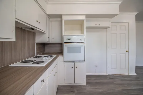 a kitchen with a stove and white cabinets