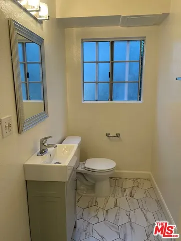 a bathroom with a sink a toilet and mirror