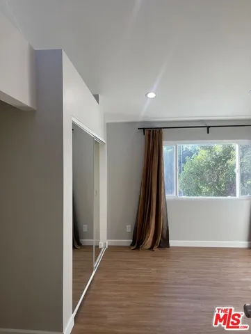 a view of a room with wooden floor and a window