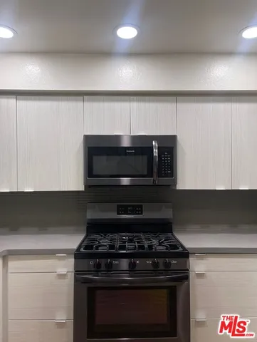 a stove top oven sitting inside of a kitchen
