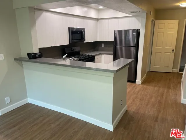 a kitchen with a refrigerator and a stove top oven