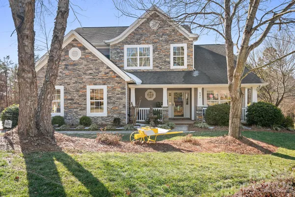 a front view of a house with swimming pool and garden