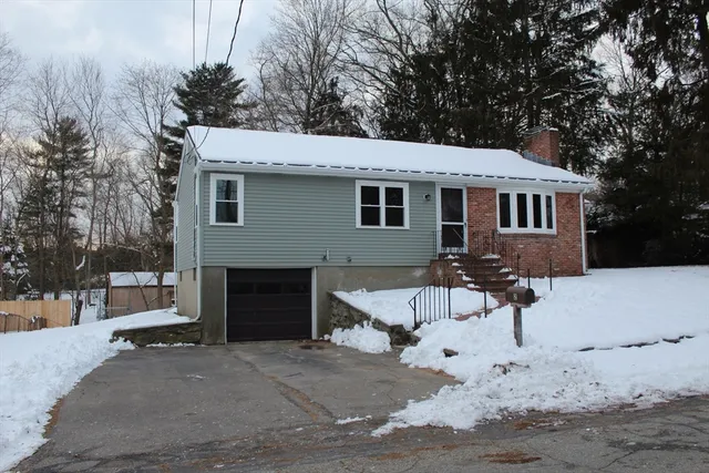 a front view of a house with a yard covered with snow in front of house
