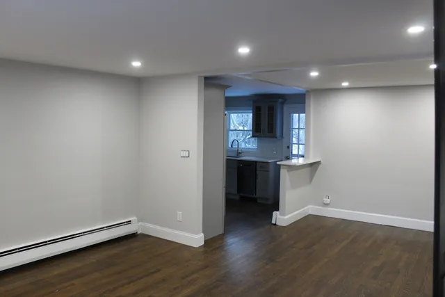an empty room with wooden floor and entrance