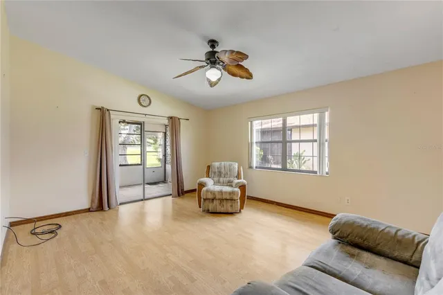 an empty room with windows and fan