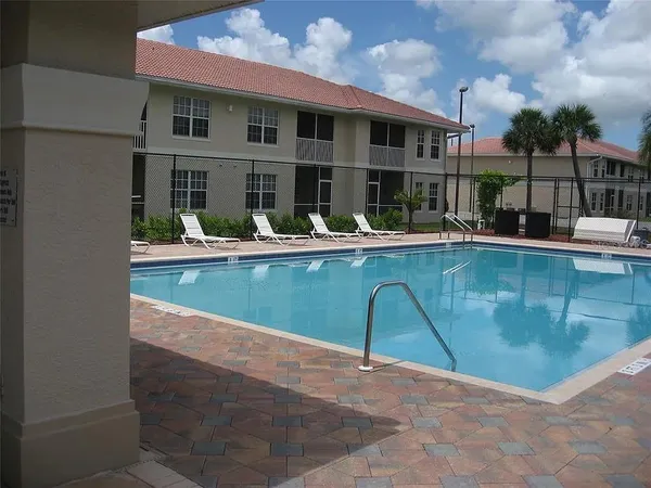 a view of house with swimming pool and a table and chairs