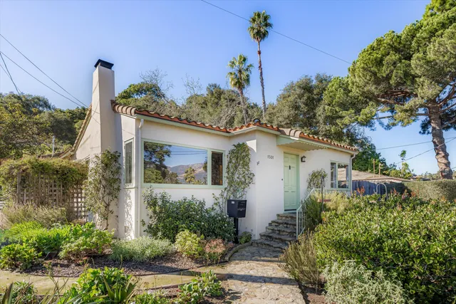 a front view of a house with a yard and potted plants