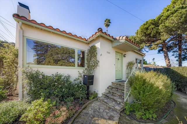 a view of a house with a small yard and floor to ceiling window