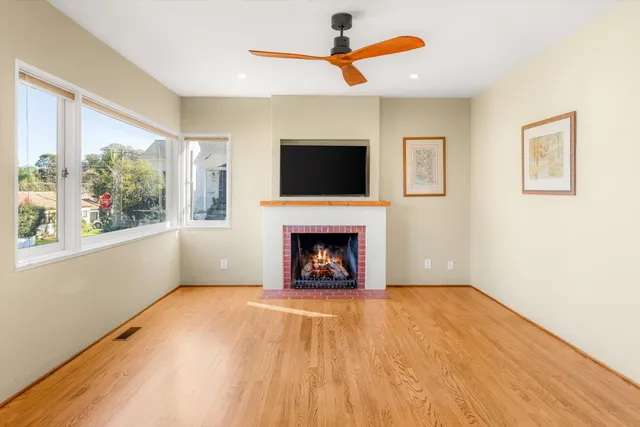 a view of an empty room with a fireplace and a window