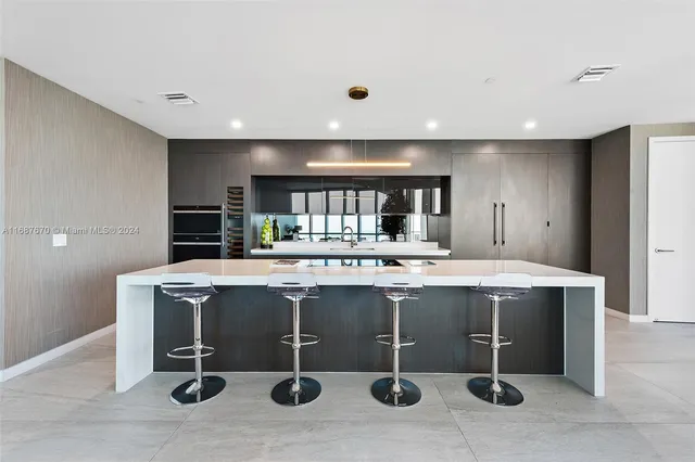 a dining room with furniture and large windows