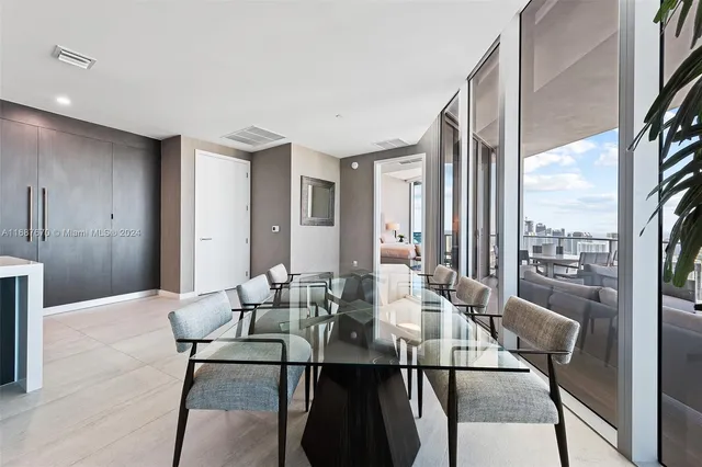 a living room with furniture a rug and a floor to ceiling window