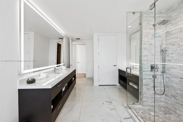 a bathroom with a double vanity sink toilet and shower