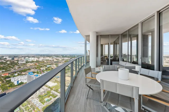 a dining room with furniture and a floor to ceiling window