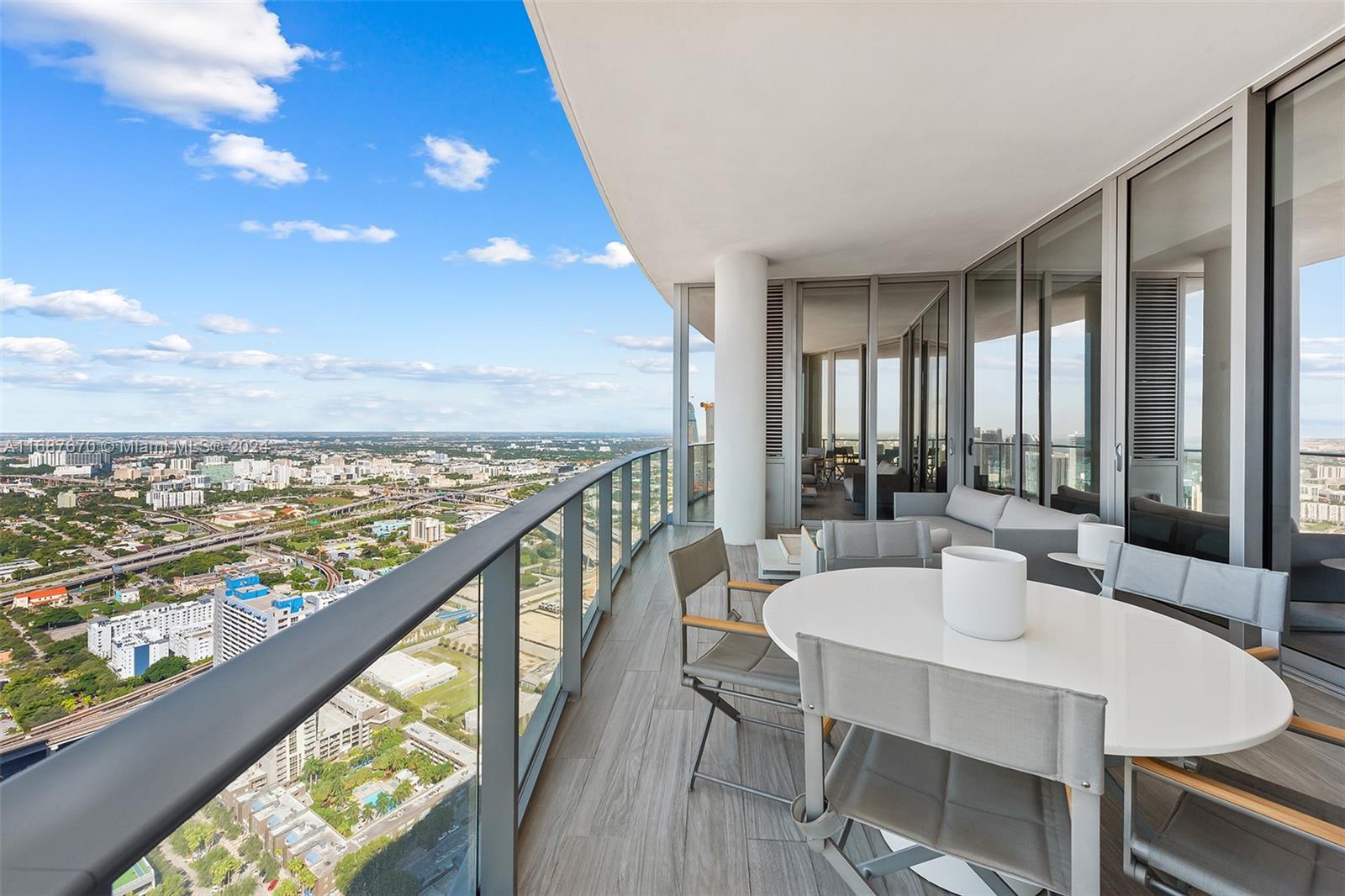 851 Northeast 1st Avenue, Unit PH5112 Miami, FL 33132 - Photo 3 of 77 a dining room with furniture and a floor to ceiling window