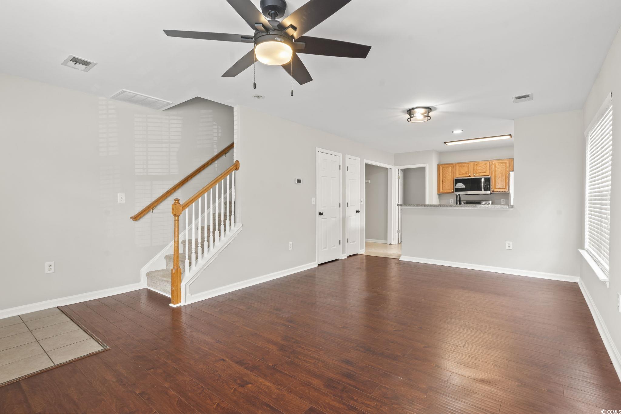 103 Barnacle Lane, Unit R5 Little River, SC 29566 - Photo 13 of 33 Unfurnished living room featuring stairway, dark wood-type flooring, and a ceiling fan