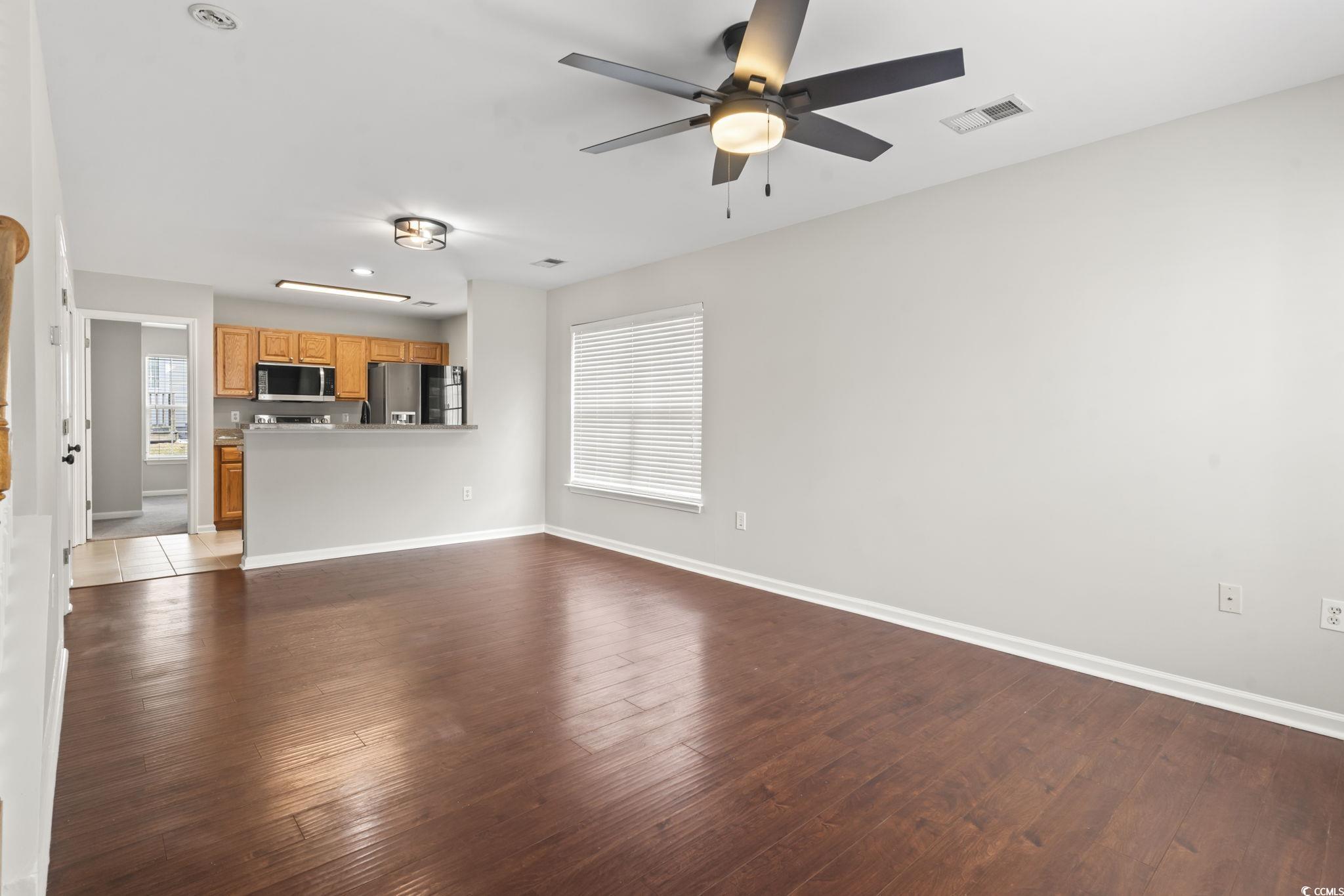 103 Barnacle Lane, Unit R5 Little River, SC 29566 - Photo 15 of 33 Unfurnished living room featuring dark wood-style floors, plenty of natural light, and a ceiling fan