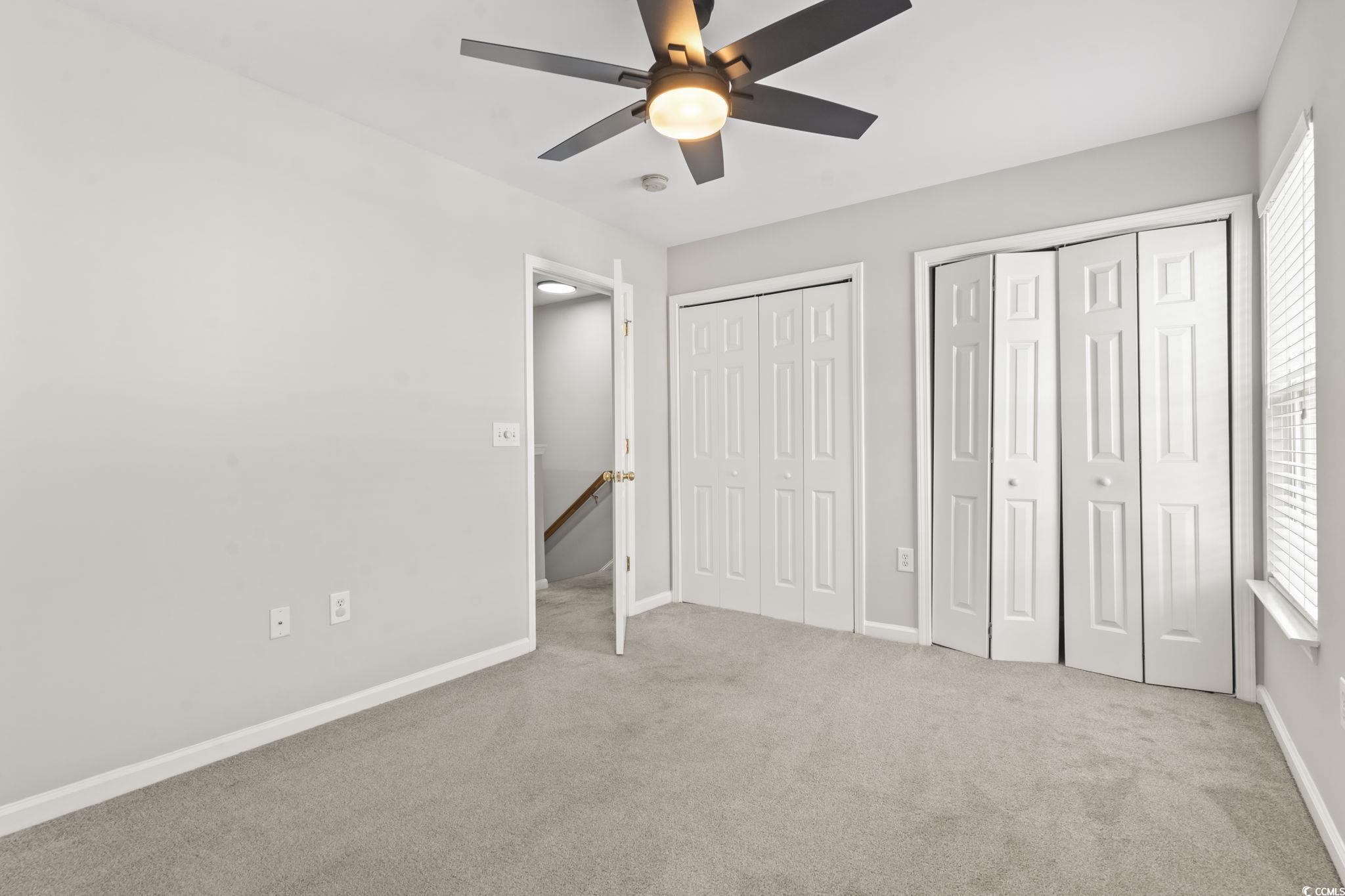 103 Barnacle Lane, Unit R5 Little River, SC 29566 - Photo 21 of 33 Unfurnished bedroom featuring two closets, light colored carpet, and ceiling fan
