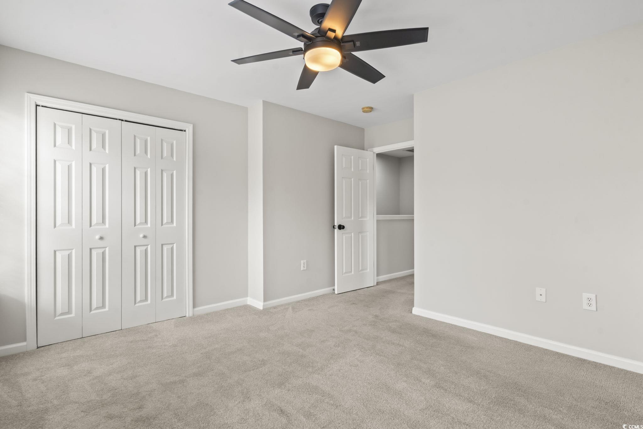 103 Barnacle Lane, Unit R5 Little River, SC 29566 - Photo 23 of 33 Unfurnished bedroom featuring carpet, a ceiling fan, and a closet
