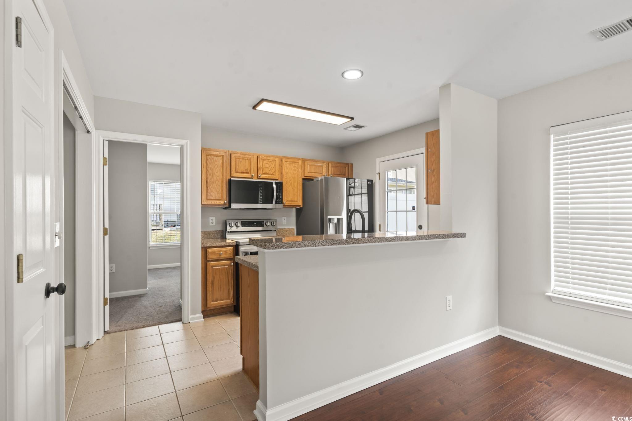 103 Barnacle Lane, Unit R5 Little River, SC 29566 - Photo 7 of 33 Kitchen featuring stainless steel appliances, plenty of natural light, a peninsula, recessed lighting, and brown cabinets