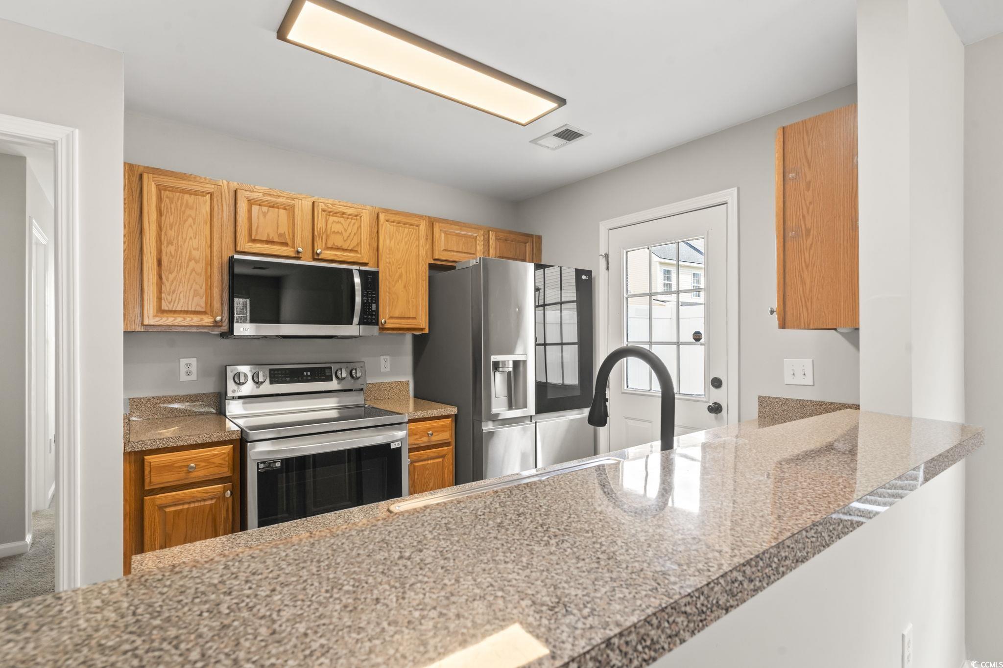 103 Barnacle Lane, Unit R5 Little River, SC 29566 - Photo 8 of 33 Kitchen with stainless steel appliances and dark stone countertops