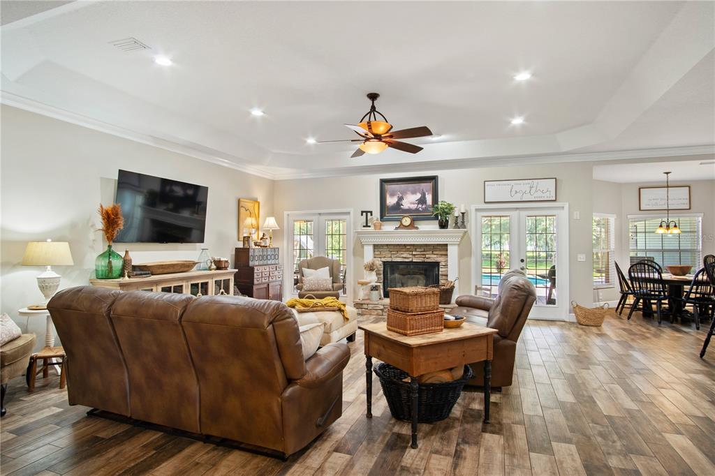 9045 Lake Hatchineha Road Kissimmee, FL 34759 - Photo 25 of 47 a living room with furniture a fireplace and a flat screen tv
