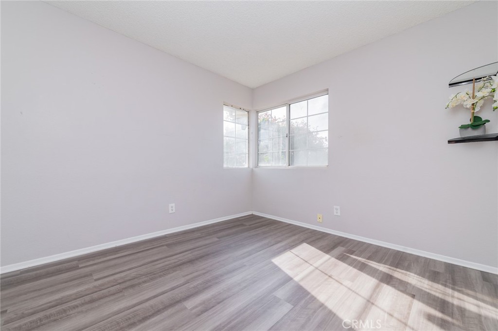 1955 Sierra Espadan Road Perris, CA 92571 - Photo 15 of 29 an empty room with wooden floor and windows