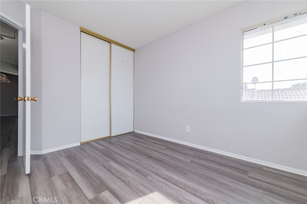 1955 Sierra Espadan Road Perris, CA 92571 - Photo 16 of 29 an empty room with wooden floor and windows