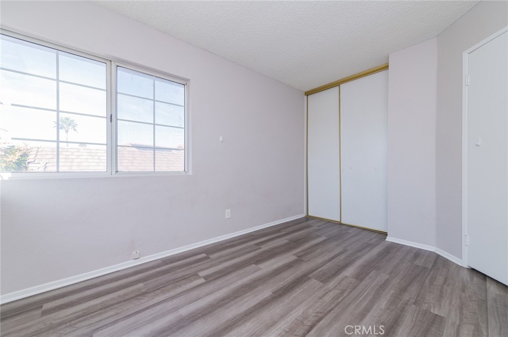 1955 Sierra Espadan Road Perris, CA 92571 - Photo 18 of 29 an empty room with wooden floor and windows