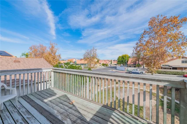 a view of a balcony with wooden floor and fence