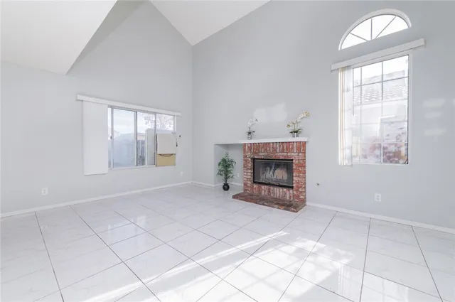 an empty room with windows and fireplace