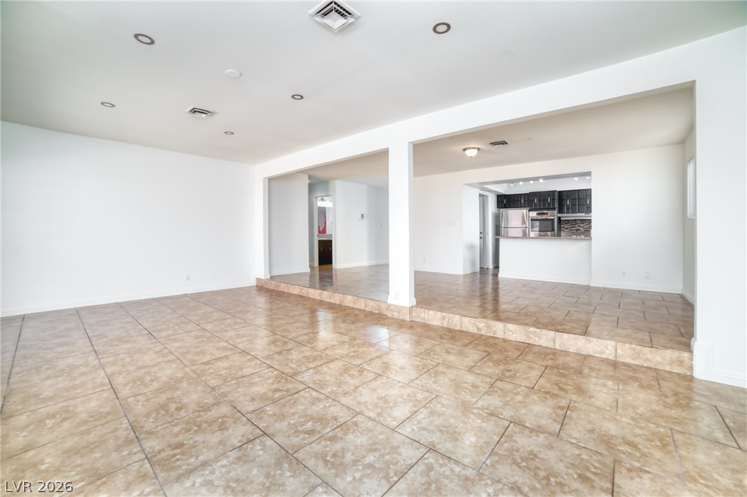 3556 Ruth Drive Las Vegas, NV 89121 - Photo 6 of 21 Step into this spacious living area, seamlessly connected to a modern kitchen with a raised floor.