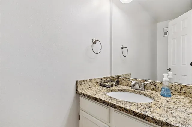 a bathroom with a granite countertop sink and a mirror