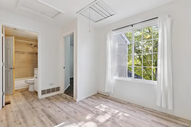 a view of a room with a large window and wooden floor